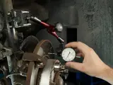 Mechanik mierzy bicie przy hamowaniu tarczy hamulcowej za pomocą czujnika zegarowego.