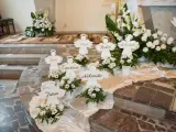 Urocze pomysły na dekoracje komunijne w kościele: aniołki z imionami dzieci i białe kwiaty tworzą magiczną atmosferę.