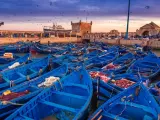 Port w Maroku, pełen błękitnych łodzi rybackich, z twierdzą w tle. Idealna pogoda na wrzesień, by podziwiać zachód słońca nad Atlantykiem.