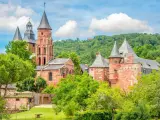 Magnifique ensemble de bâtiments en pierre rouge, dont une église romane et des tours, au milieu d'une végétation luxuriante. Idéal pour découvrir que faire autour de Rocamadour.