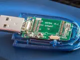 Rozłożony pendrive z widoczną zieloną płytką drukowaną i złączem USB. Widać elementy elektroniczne, oznaczenia jak "6015U1 V1.1" i "exfat" (choć nie widać go na obrazku, można założyć, że jest to format pliku).