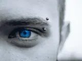 Intensywne, niebieskie oko z kolczykiem w brwi.