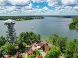 Wieża widokowa nad jeziorem, idealne miejsce na podziwianie kaszubskiego krajobrazu. Żaglówka na wodzie, las i błękitne niebo.