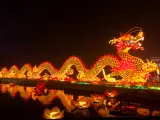 Wspaniały, świetlisty smok chiński znak zodiaku, ozdobiony lampionami w kształcie kwiatów lotosu, odbija się w wodzie.
