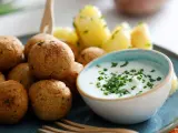 Polpette di ceci dorate e croccanti, servite con patate novelle e una ciotola di salsa cremosa guarnita con erba cipollina.