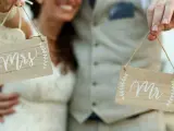 Para młoda trzyma tabliczki "Mrs" i "Mr". Zastanawiasz się, ile kosztuje zmiana nazwiska po ślubie?