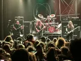Concert de metal, musiciens sur scène, foule en délire. Le groupe semble prêt à envoyer du lourd, un vrai voyage ad patres pour les fans.