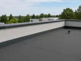 Płaski dach z attyką, czyli nadbudową ściany na krawędzi dachu, chroniącą przed wiatrem i deszczem.