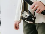 Elegancki wędkarz z kołowrotkiem karpiowym YF 4000 i przynętą w kształcie ryby.