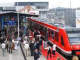 Czerwony pociąg na peronie dworca Szczecin Główny, gotowy do podróży do Berlina. Ludzie czekają na platformie.