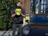 Man holding a fluffy wash mitt, ready to demonstrate how to wash a convertible car.