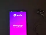 Telefon z aplikacją Spotify i słuchawkami. Idealne do słuchania wzruszających piosenek o przyjaźni.