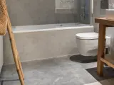 Baño moderno con bañera, inodoro suspendido y lavabo de madera. ¿Cuánto cuesta cambiar bañera por plato de ducha?