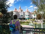 Dziewczyna z plecakiem w kształcie Myszki Miki podziwia zamek w Disneyland Paris. Bilety do parku już kupione, czas na przygodę!