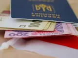 Ukraiński paszport z pieniędzmi, symbolizujący nadzieję na godną emeryturę dla Ukraińców w Polsce.