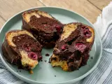 Drei saftige Stücke Marmorkuchen mit Kirschen und Schokoladenglasur auf einem Teller.