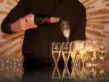 Kelner nalewa szampan Moët & Chandon do kieliszków, przygotowując się do wesela.