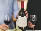 Para świętuje, trzymając butelkę wina. Pamiętaj, wino im starsze tym lepsze.