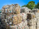 Ogromne bele sprasowanych plastikowych butelek tworzą krajobraz wysypiska śmieci. Kolorowe nakrętki dodają im niepokojącego uroku.