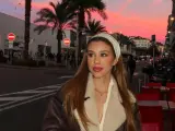 Maria Jelewska, w wieku nastoletnim, na tle zachodzącego słońca i palm.