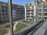 Nowoczesne bloki mieszkalne z balkonami, zabezpieczone siatką. Zastanawiasz się, ile kosztuje montaż siatki na balkonie?