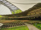 Puste rzędy siedzeń w amfiteatrze w Sopocie czekają na widzów. Nowoczesna konstrukcja dachu i otoczenie zieleni tworzą wyjątkową atmosferę.
