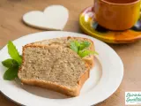 Zwei Scheiben saftiger Becherkuchen mit Joghurt, garniert mit Minze, neben einer Tasse Kaffee.