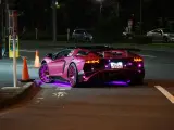 Różowy Lamborghini z neonowym podświetleniem na ulicy nocą.