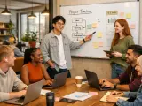 Ein junges, diverses Team plant eine Projekt-Timeline. Der Sprecher erklärt die Phasen Ideen, Planung und Entwicklung. Die Gen Z arbeitet engagiert an Laptops.