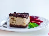Sernik królewski stary przepis z bakaliami i polewą czekoladową, udekorowany truskawkami i miętą.