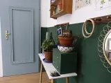 Malowanie drzwi na niebiesko nadało im nowy, świeży wygląd. Wnętrze zdobią rośliny i ozdobne przedmioty.