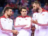 Trzech siatkarzy w strojach z biało-czerwoną flagą Polski. Jeden z nich trzyma puchar, symbolizujący, kto jest aktualnym mistrzem świata w siatkówce.