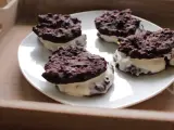 Cztery domowe ciastka z kremem, przypominające Oreo, na białym talerzu. Pyszna przekąska, choć warto sprawdzić oreo kcal przed zjedzeniem.