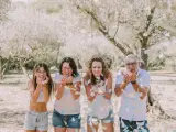 Photographie lifestyle : une famille lance des confettis sous des arbres fleuris, un moment de joie capturé.