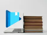 Laptop z ikoną książki i stosem książek. Jak otworzyć plik epub?
