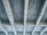 Betonowy strop z widocznymi belkami i płytami. Szukając, jaki strop najtańszy, warto rozważyć takie proste konstrukcje.