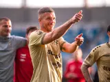 Uśmiechnięty Lukas Podolski pokazuje kciuk w górę, jakby podsumowywał swoje świetne statystyki.