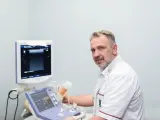 Ortopeda w białym fartuchu przy aparacie USG.