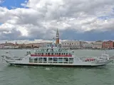 Traghetto ACTV che naviga sul Canal Grande, con lo sfondo di Venezia e il Palazzo Ducale.