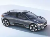 Elegancki, szary Jaguar I-PACE, niczym czarny jaguar gotowy do skoku, prezentuje swoją aerodynamiczną sylwetkę na jasnym tle.