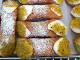 Chrupiące rurki wypełnione kremem i posypane pistacjami. Te pyszne **cannoli** wyglądają jak dzieła sztuki cukierniczej.