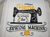 Tipografía para bordar: "Home is where the SEWING MACHINE is". Máquina de coser vintage bordada en negro y dorado.