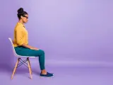 Donna seduta su una sedia, con le mani appoggiate sulle ginocchia, in una posa che suggerisce le **tecniche di grounding** per ritrovare la calma.