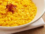 Miseczka kremowego risotto alla Milanese, ozdobiona nitkami szafranu.