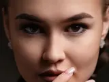 Un gros plan sur le visage d'une femme, ses sourcils parfaitement dessinés après une séance d'épilation.