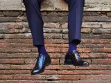Uomo con calzini blu a pois bianchi e scarpe nere lucide. Un perfetto abbinamento calzini scarpe uomo per un look elegante.