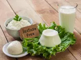 Serek wiejski, kulka mozzarelli i ser w kształcie stożka na sałacie, obok szklanki mleka. Etykieta głosi "lactose free", co oznacza brak laktozy.