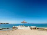 Słoneczny dzień na plaży w Simuni camping. Leżaki pod parasolem, dmuchany plac zabaw w wodzie i błękitne morze.
