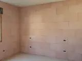 Pannelli rosa per cappotto interno con lana di roccia e cartongesso, con predisposizioni per prese elettriche e una finestra.