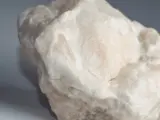 Surowy, biały alabaster o matowej powierzchni, z delikatnymi, kremowymi przebarwieniami.